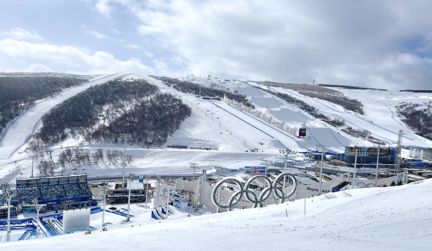 Snow-covered ski resort in Zhangjiakou, China, with mountain backdrop
