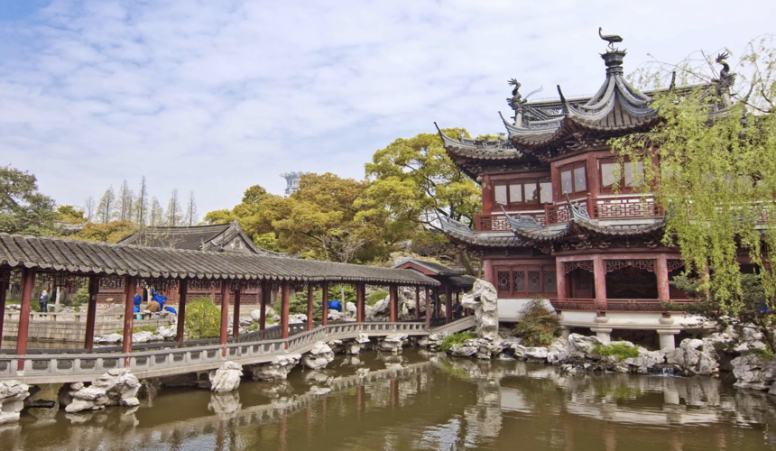  A classical Chinese garden with traditional architecture and a nearby bustling marketplace.