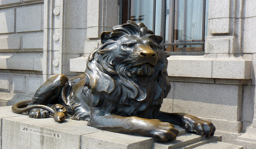 Traditional Chinese guardian lion statues at the entrances of historic buildings along the Bund, symbolizing protection and strength.