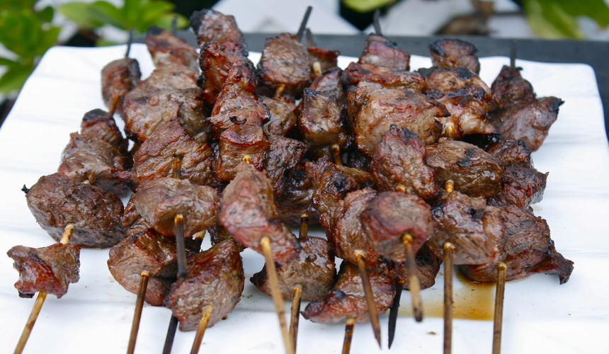 Grilled lamb skewers (chuan’r) on open flame, a popular Beijing street food.