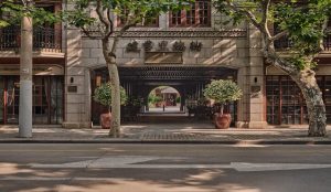 Tree-lined street in Shanghai’s French Concession with colonial-era buildings and cafes.
