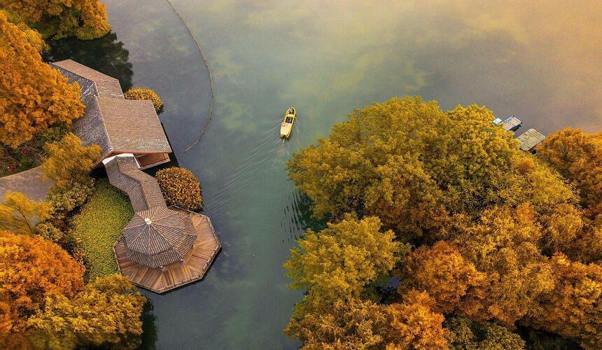 Serene West Lake surrounded by pagodas, willow trees, and tea plantations in Hangzhou