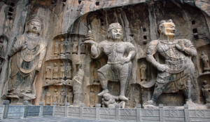 Ancient Buddhist statues carved into limestone cliffs at Longmen Grottoes in Luoyang