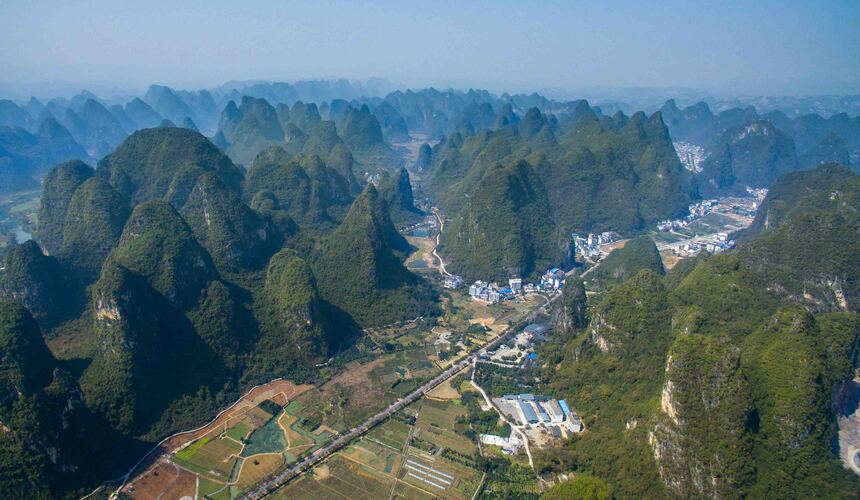 Climber scaling limestone karst cliffs in Yangshuo, Guangxi, China
