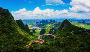 Panoramic view of Ruyi Peak Scenic Spot in Yangshuo, Guangxi, featuring winding mountain paths and lush karst peaks.