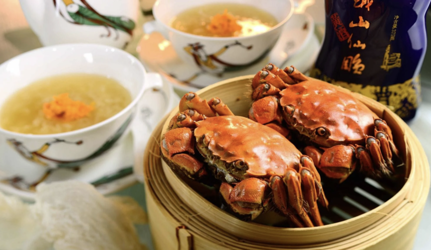 Freshly steamed Shanghai hairy crab on a bamboo platter with dipping sauce.