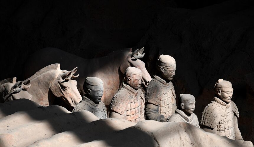 Rows of life-sized terracotta warriors standing in archaeological excavation pits in Xi’an