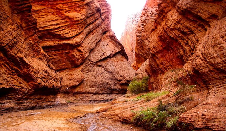 Dramatic red sandstone cliffs and winding paths of Tianshan Grand Canyon in Xinjiang