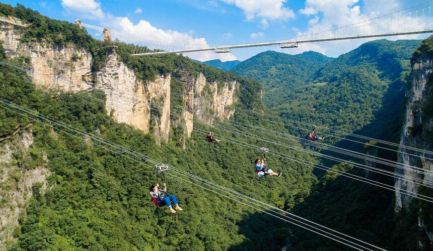 Tourist ziplining over misty cliffs in Zhangjiajie National Forest Park, Hunan