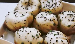 Golden pan-fried sheng jian bao buns with crispy bottoms and juicy pork filling.