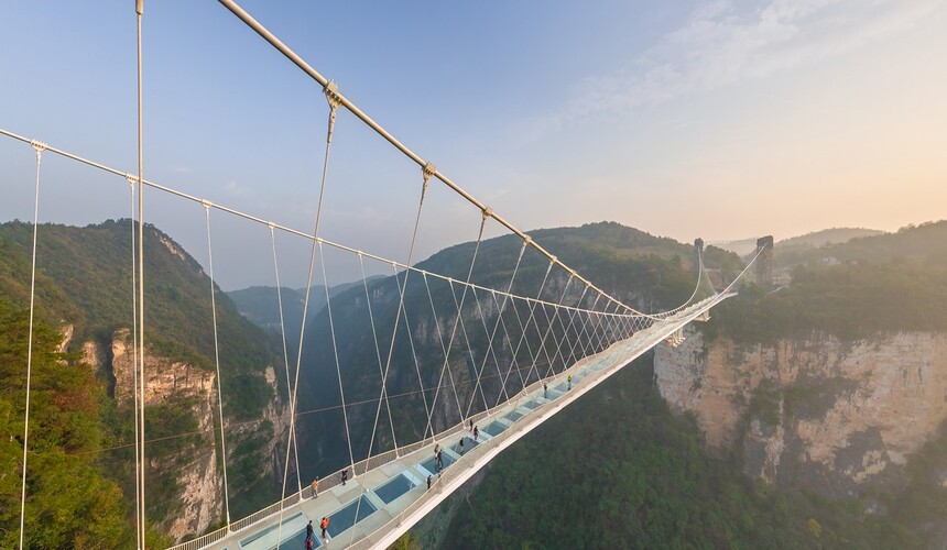 Tourists walking on the Glass Bridge over Zhangjiajie Grand Canyon in China