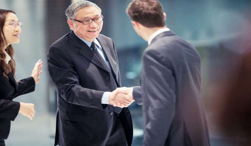 Two businesspeople shaking hands as a common greeting in China