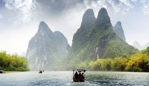 Panoramic view of Guilin’s karst mountains and Li River under a blue sky.