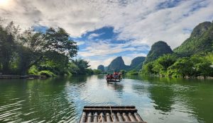 Peaceful Yulong River surrounded by lush green hills and countryside.