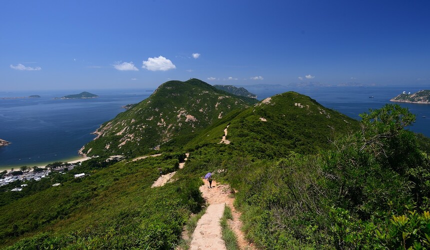 Hiking trail on Dragon’s Back ridge with panoramic coastal and mountain views.