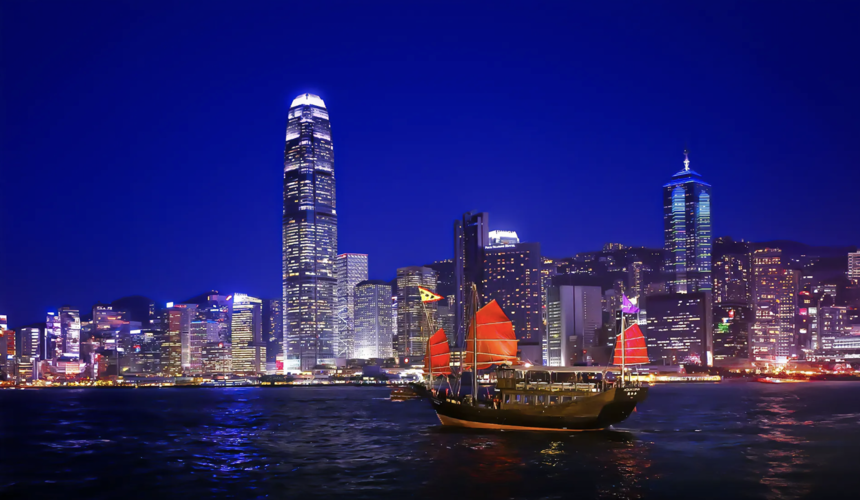 Victoria Harbour sunset cruise with glowing skyline and calm waters.
