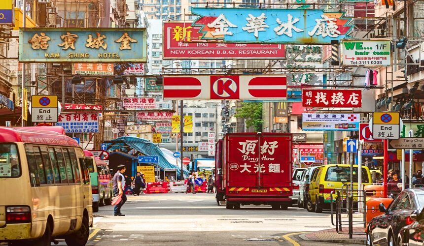 Crowded streets of Mong Kok filled with neon lights, street signs, and busy pedestrians.