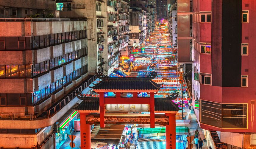 Bustling Temple Street Night Market with colorful stalls and neon signs. 