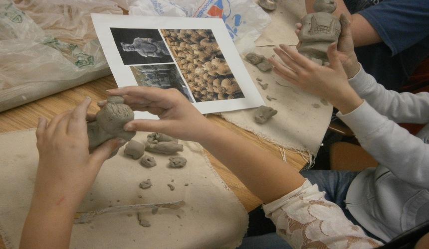Tourist painting a miniature Terracotta Warrior figurine in Xi’an workshop