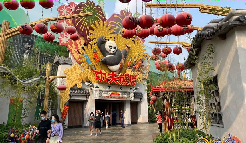 A panoramic view of Universal Beijing's grand entrance, showing the large, rotating Universal globe with the words "UNIVERSAL BEIJING" in bold red letters.