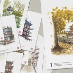 Traveler writing a postcard in a Chinese café with scenic cards and local souvenirs on the table.