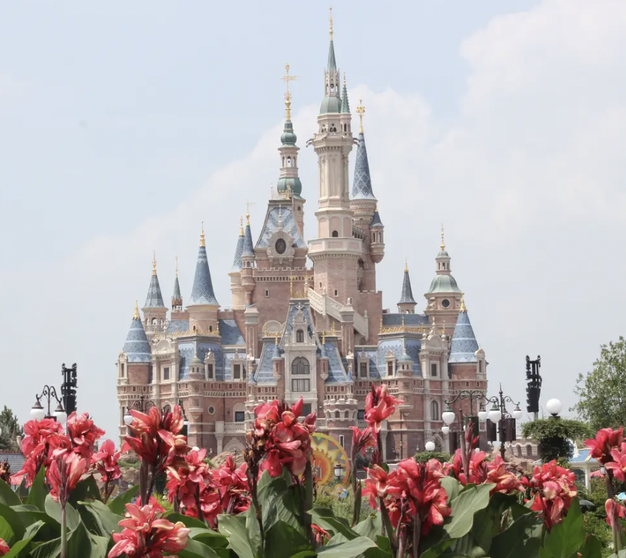 A view of Shanghai Disneyland's iconic Enchanted Storybook Castle, set against a vibrant sky in China.