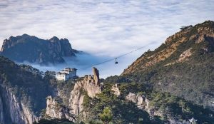 Misty sunrise over Huangshan Yellow Mountain with jagged granite peaks and ancient pine trees in China.