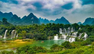 Massive cross-border waterfall between China and Vietnam, surrounded by lush jungle.