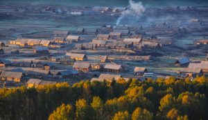 Tranquil wooden village of the Kazakh people nestled among alpine forests and rivers.