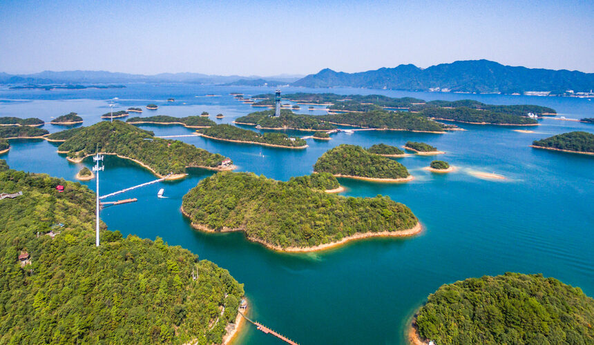 Divers exploring the clear waters of Qiandao Lake with submerged ancient ruins.
