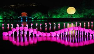 Impression West Lake outdoor performance in Hangzhou set on the water with dancers, lights, and scenic West Lake views.