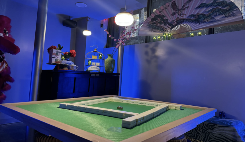 Midnight mahjong parlor in China with locals playing tiles under bright lights late at night.