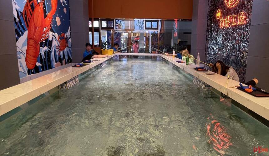Nighttime shrimp fishing pond in China where visitors catch live shrimp under illuminated pools.
