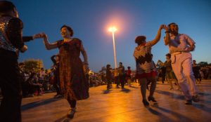 Public square dancing groups in China with residents dancing together in the evening.