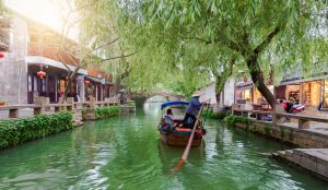 Ancient canal and stone bridge in Suzhou water town during spring.