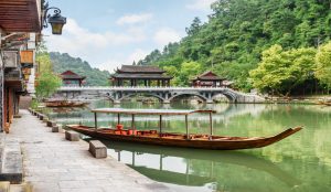 Scenic landscape in China featuring mountains, rivers, and traditional architecture.
