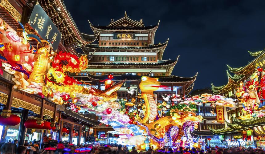 Shanghai skyline featuring modern skyscrapers and the Huangpu River at sunset.