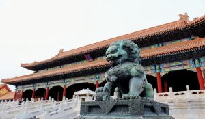 Stone guardian lion statue at the Forbidden City gate with detailed carvings and traditional imperial symbolism.