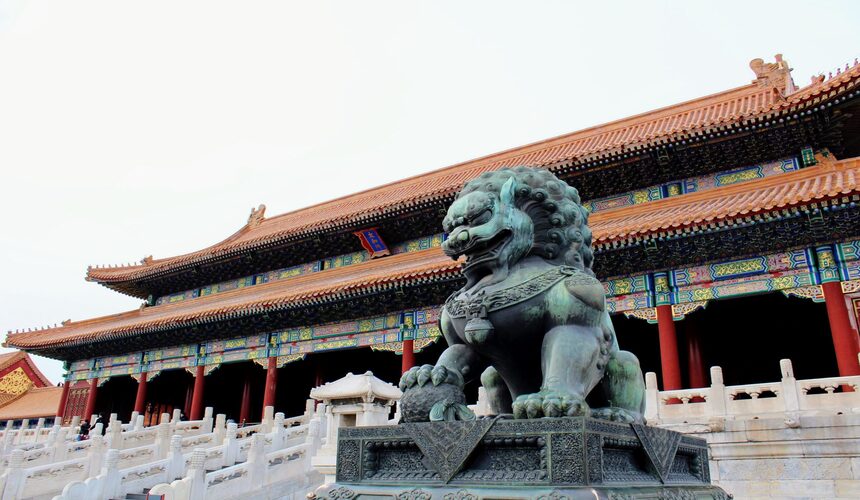 Stone guardian lion statue at the Forbidden City gate with detailed carvings and traditional imperial symbolism.