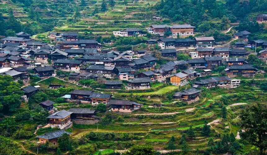 Traditional ethnic minority village nestled among karst mountains and lush countryside in Guizhou