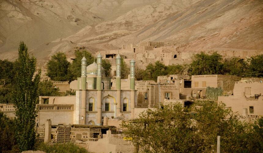 Traditional oasis town surrounded by desert and distant mountains in Xinjiang, northwest China