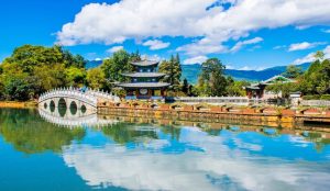 Mountain hiking trail overlooking dramatic river gorges and snow-capped peaks in Yunnan Province