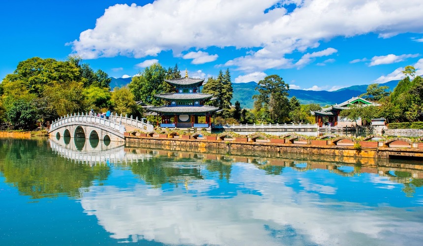 Mountain hiking trail overlooking dramatic river gorges and snow-capped peaks in Yunnan Province