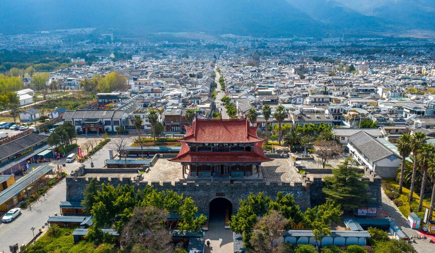 Ancient city gates and traditional Bai architecture with mountains in the distance in Dali Ancient Town, Yunnan, China.