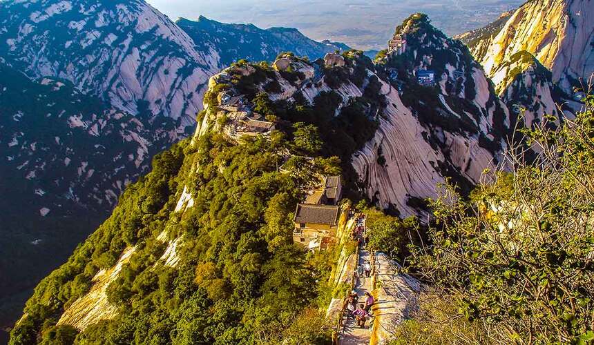 Visitors hiking along the famous cliffside paths of Mount Hua in China.