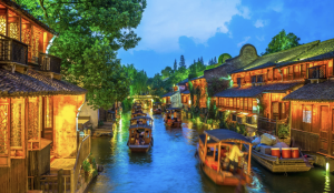 Historic canals, stone bridges, and riverside buildings illuminated in Wuzhen Water Town, Zhejiang, China.